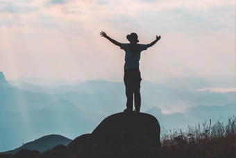 silhouette of a person with raised hands